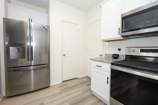 2326 Carrabelle Way, Sanford, FL 32771 - kitchen with stainless steel appliances, light wood-type flooring, white cabinetry, and light stone counters