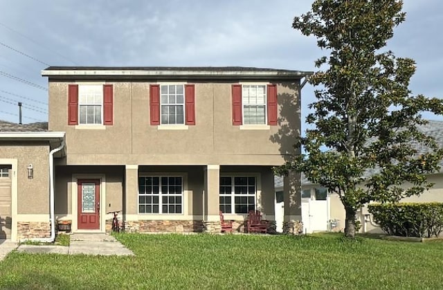 2383 Winding Cv, Oviedo, FL 32765 - view of front of home with stucco siding, a front yard, stone siding, and an attached garage