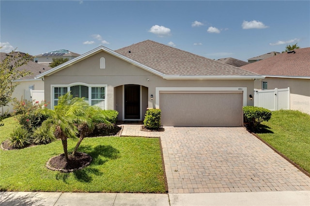 480 Kestrel Dr, Groveland, FL 34736 - ranch-style home featuring an attached garage, decorative driveway, roof with shingles, and stucco siding