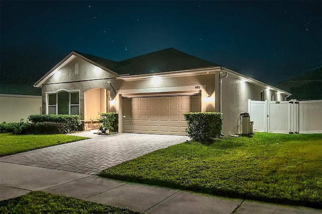 480 Kestrel Dr, Groveland, FL 34736 - ranch-style home with stucco siding, decorative driveway, and a garage