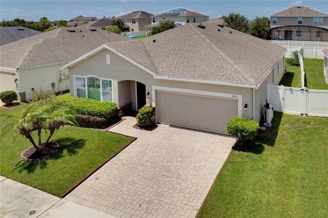 480 Kestrel Dr, Groveland, FL 34736 - view of front of home featuring an attached garage, stucco siding, decorative driveway, and a gate