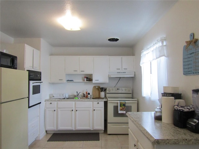 5010 Shoshone St, Orlando, FL 32819 - kitchen with white appliances, under cabinet range hood, light countertops, and white cabinets