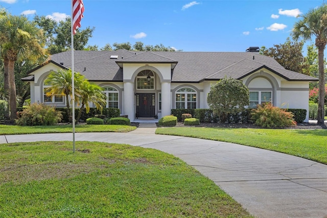 5141 Autumn Ridge Ln, Windermere, FL 34786 - view of front of home with stucco siding, a front yard, and roof with shingles