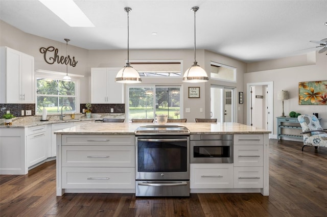 5141 Autumn Ridge Ln, Windermere, FL 34786 - kitchen with electric range, a skylight, white cabinetry, and decorative backsplash