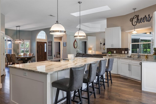 5141 Autumn Ridge Ln, Windermere, FL 34786 - kitchen with dark wood-type flooring, a kitchen island, backsplash, and white cabinets