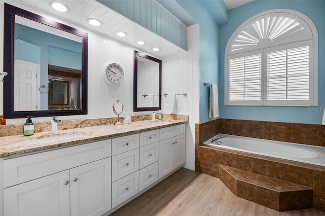 5141 Autumn Ridge Ln, Windermere, FL 34786 - bathroom with double vanity, a bath, wood finished floors, and a stall shower