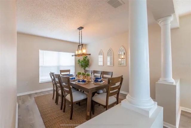 365 Aylesbury Ct, Kissimmee, FL 34758 - dining space with ornate columns, a textured ceiling, plenty of natural light, and wood finished floors