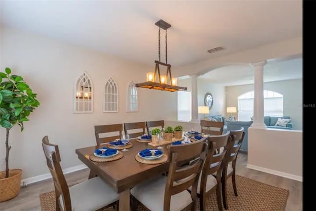 365 Aylesbury Ct, Kissimmee, FL 34758 - dining space with decorative columns, arched walkways, and wood finished floors