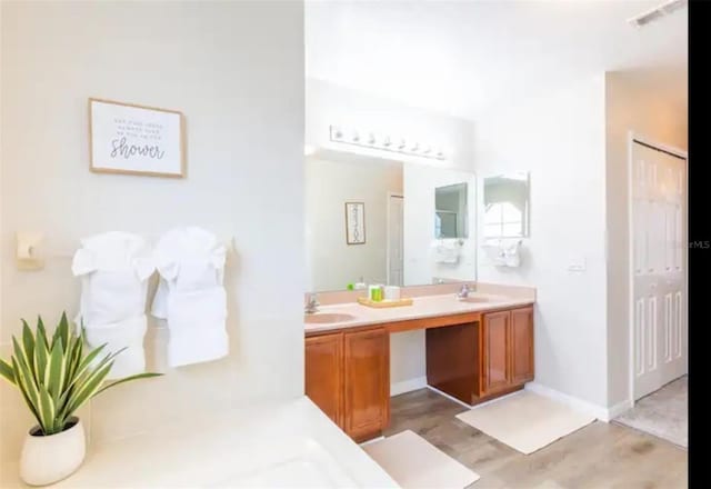 365 Aylesbury Ct, Kissimmee, FL 34758 - bathroom featuring double vanity and wood finished floors