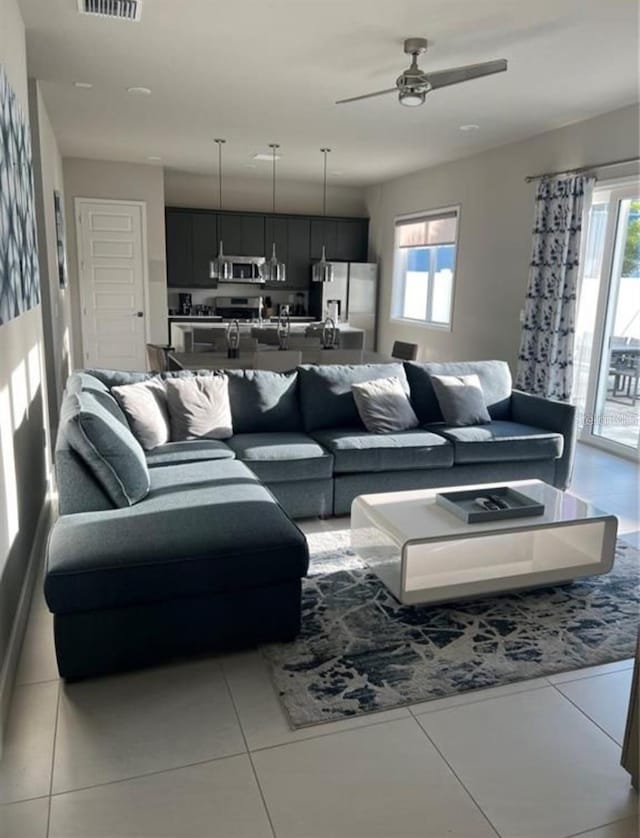 7740 Sandy Ridge Dr Unit 102, Reunion, FL 34747 - living area with healthy amount of natural light, light tile patterned floors, and ceiling fan