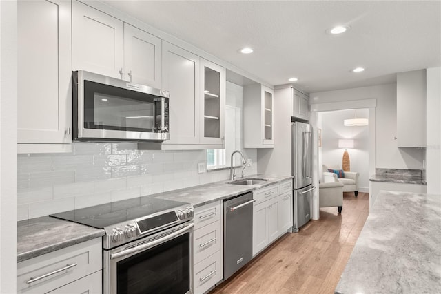 91 Minnehaha Cir, Maitland, FL 32751 - kitchen featuring appliances with stainless steel finishes, recessed lighting, white cabinets, light stone counters, and glass insert cabinets