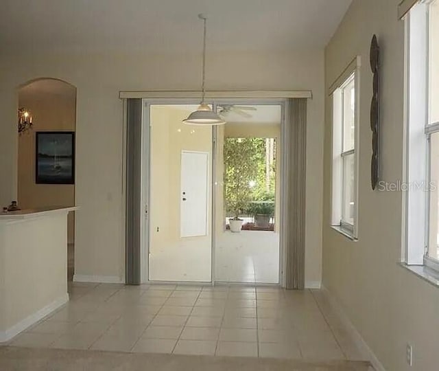 37 Ethan Allen Dr, Palm Coast, FL 32164 - unfurnished dining area with arched walkways, light tile patterned flooring, and a ceiling fan