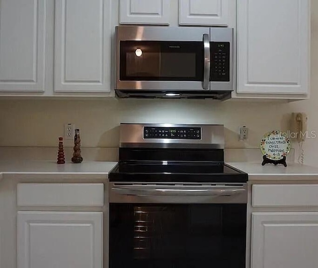 37 Ethan Allen Dr, Palm Coast, FL 32164 - kitchen with appliances with stainless steel finishes, white cabinetry, and light countertops