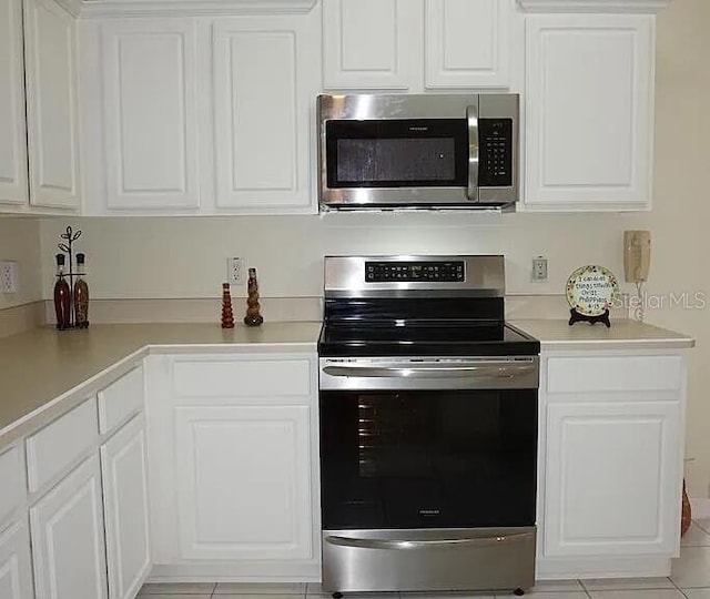 37 Ethan Allen Dr, Palm Coast, FL 32164 - kitchen featuring stainless steel appliances, white cabinets, light countertops, and light tile patterned flooring