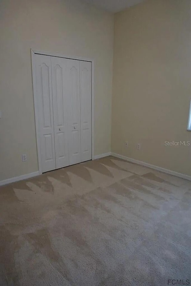 37 Ethan Allen Dr, Palm Coast, FL 32164 - unfurnished bedroom with carpet and a closet