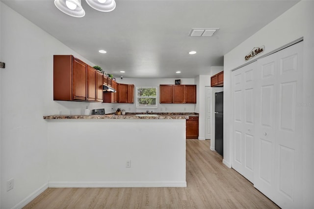9 Summerset Ter, Casselberry, FL 32707 - kitchen featuring freestanding refrigerator, light wood finished floors, a peninsula, recessed lighting, and light stone counters