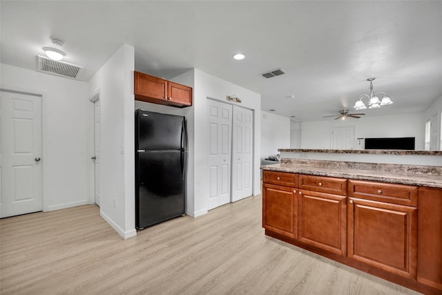 9 Summerset Ter, Casselberry, FL 32707 - kitchen with freestanding refrigerator, light wood finished floors, a chandelier, a ceiling fan, and brown cabinetry