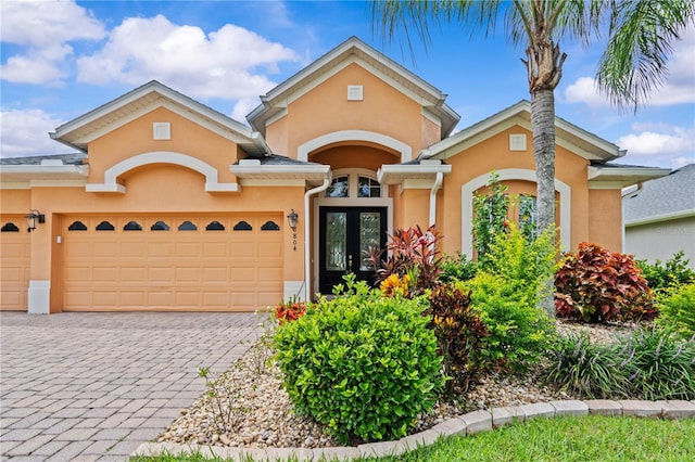 8804 Warwick Shore Xing Unit X, Orlando, FL 32829 - view of front of property with stucco siding, french doors, a garage, and decorative driveway