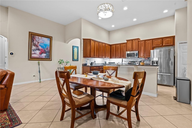 8804 Warwick Shore Xing Unit X, Orlando, FL 32829 - dining room with light tile patterned floors, arched walkways, a high ceiling, and recessed lighting