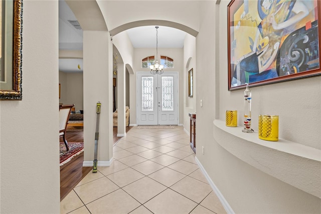 8804 Warwick Shore Xing Unit X, Orlando, FL 32829 - foyer with arched walkways, a chandelier, light tile patterned floors, and stairs