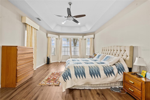 8804 Warwick Shore Xing Unit X, Orlando, FL 32829 - bedroom featuring a raised ceiling, wood finished floors, and a ceiling fan