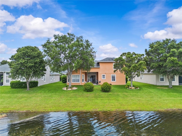 8804 Warwick Shore Xing Unit X, Orlando, FL 32829 - rear view of property featuring stucco siding, a lawn, and a water view