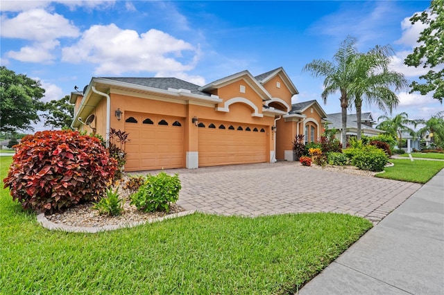 8804 Warwick Shore Xing Unit X, Orlando, FL 32829 - view of front of home featuring stucco siding, an attached garage, a front yard, and decorative driveway