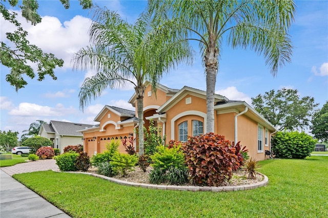 8804 Warwick Shore Xing Unit X, Orlando, FL 32829 - view of front of home featuring stucco siding, an attached garage, a front lawn, and driveway