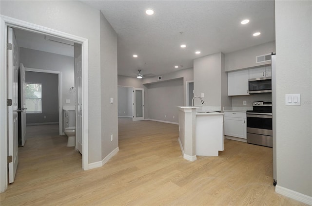 826 Camargo Way Unit 201, Altamonte Springs, FL 32714 - kitchen with stainless steel appliances, recessed lighting, light wood-style floors, open floor plan, and white cabinets