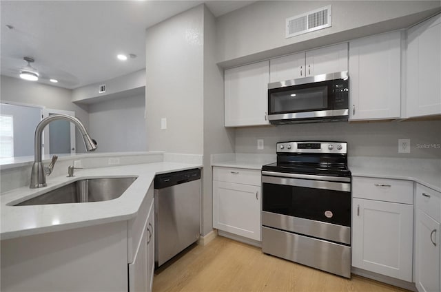 826 Camargo Way Unit 201, Altamonte Springs, FL 32714 - kitchen with stainless steel appliances, light wood-style flooring, white cabinets, recessed lighting, and light stone countertops