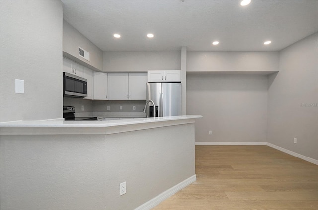 826 Camargo Way Unit 201, Altamonte Springs, FL 32714 - kitchen with stainless steel appliances, light wood-style floors, a peninsula, recessed lighting, and light countertops