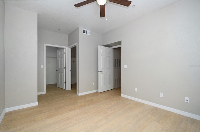 826 Camargo Way Unit 201, Altamonte Springs, FL 32714 - unfurnished bedroom featuring light wood-style flooring, a walk in closet, a ceiling fan, and a closet