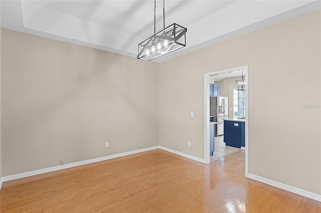 403 Courtlea Creek Dr, Winter Garden, FL 34787 - empty room featuring a chandelier, light wood-style floors, and a raised ceiling