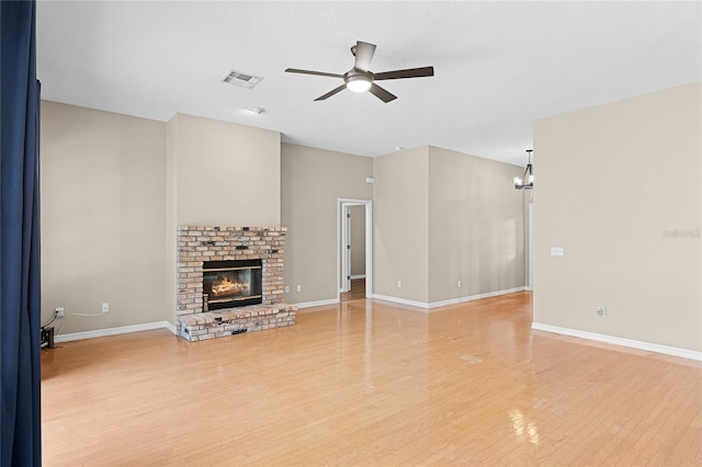 403 Courtlea Creek Dr, Winter Garden, FL 34787 - unfurnished living room featuring ceiling fan, light wood finished floors, a fireplace, and a chandelier