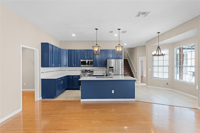 403 Courtlea Creek Dr, Winter Garden, FL 34787 - kitchen with appliances with stainless steel finishes, blue cabinetry, a chandelier, decorative backsplash, and light countertops