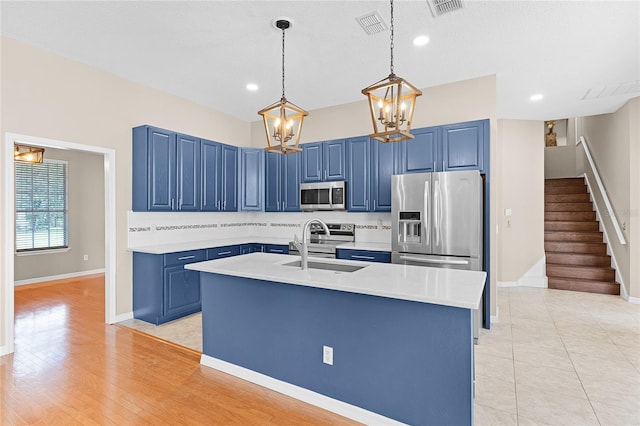 403 Courtlea Creek Dr, Winter Garden, FL 34787 - kitchen with stainless steel appliances, blue cabinets, light countertops, decorative light fixtures, and a chandelier
