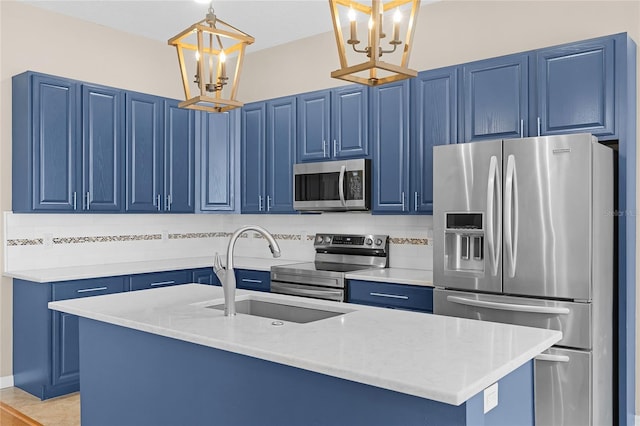 403 Courtlea Creek Dr, Winter Garden, FL 34787 - kitchen with stainless steel appliances, blue cabinets, a chandelier, and pendant lighting