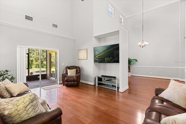 7348 Regina Way, Orlando, FL 32819 - living room featuring a high ceiling, wood finished floors, and a chandelier