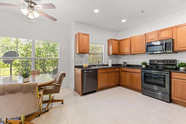 7348 Regina Way, Orlando, FL 32819 - kitchen featuring stainless steel appliances, dark countertops, recessed lighting, a ceiling fan, and brown cabinetry