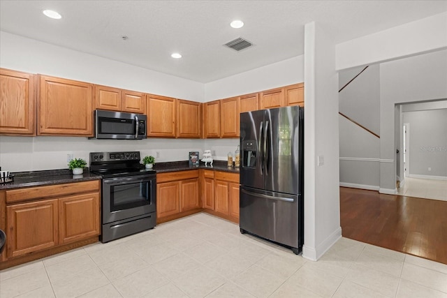 7348 Regina Way, Orlando, FL 32819 - kitchen featuring refrigerator with ice dispenser, electric range oven, stainless steel microwave, dark countertops, and brown cabinetry