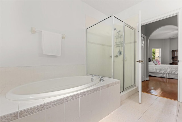 7348 Regina Way, Orlando, FL 32819 - ensuite bathroom with a bath, a stall shower, and tile patterned floors