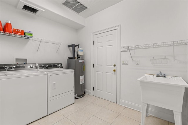 7348 Regina Way, Orlando, FL 32819 - washroom with electric water heater, washer and clothes dryer, and light tile patterned flooring