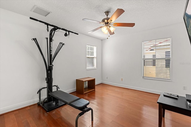7348 Regina Way, Orlando, FL 32819 - exercise area with ceiling fan, wood finished floors, and a textured ceiling