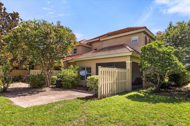 7348 Regina Way, Orlando, FL 32819 - rear view of property with a tile roof, stucco siding, and a patio
