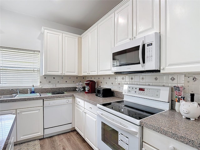 799 Hacienda Cir, Kissimmee, FL 34741 - kitchen with white appliances, white cabinets, decorative backsplash, and light wood finished floors
