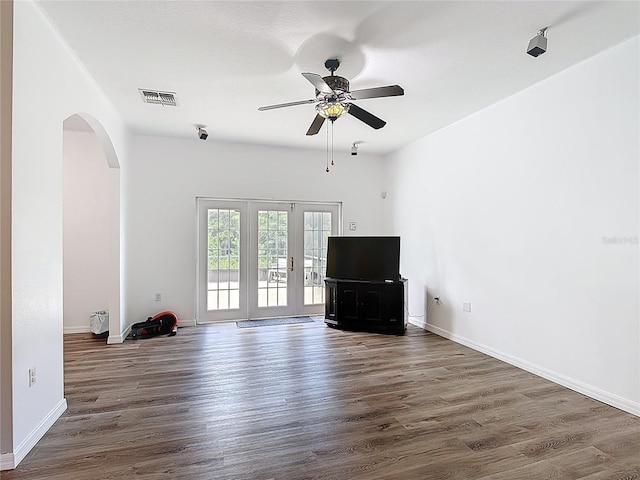 799 Hacienda Cir, Kissimmee, FL 34741 - unfurnished living room with arched walkways, a ceiling fan, and wood finished floors