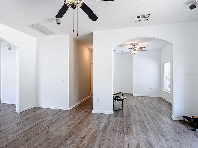 799 Hacienda Cir, Kissimmee, FL 34741 - unfurnished living room with a ceiling fan, arched walkways, and wood finished floors