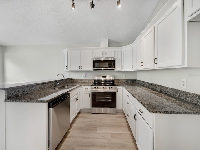 101 Whitley Bay Ln, Longwood, FL 32779 - kitchen with stainless steel appliances, white cabinetry, a textured ceiling, and a peninsula