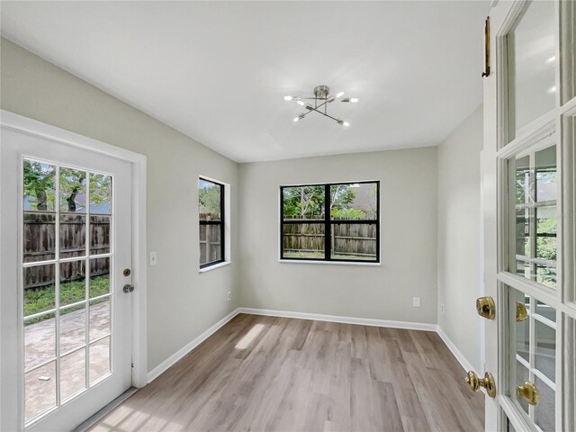 101 Whitley Bay Ln, Longwood, FL 32779 - spare room with a chandelier, light wood-style flooring, and french doors