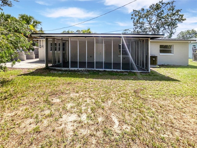 2607 Castle Oak Ave, Orlando, FL 32808 - rear view of house with a sunroom, a lawn, and stucco siding